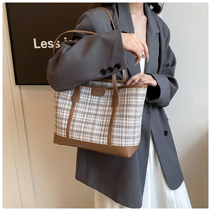 Detail of the plaid tote bag featuring brown leather trim and SMART BAGS brand tag