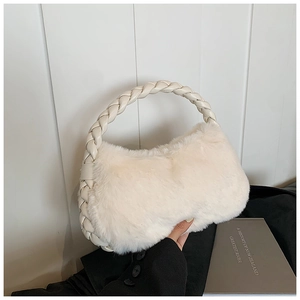 Détail de la texture en fausse fourrure crème et de la poignée en cuir tressé du sac à main