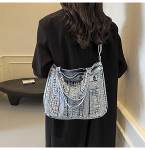 Detailed view of washed blue denim tote bag featuring vertical pleated stitching and large capacity