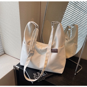 Détail du grand sac cabas en toile avec bandoulière réglable et poche latérale