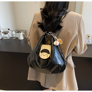 Detail of black leather cloud backpack with baseball cartoon patch and glove charms