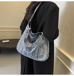 Detailed view of vintage light blue denim tote bag with dual handles and side pocket