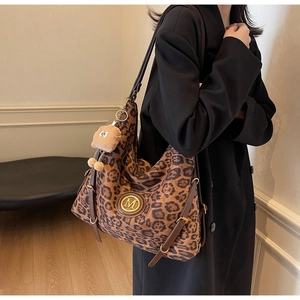 Detail of large leopard print tote bag with metal M logo and plush bear accessory