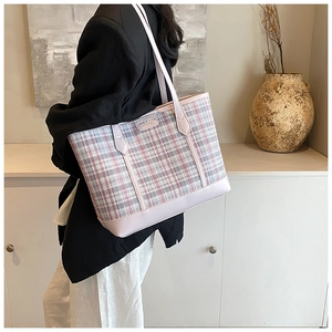 Close-up of a pink plaid large tote bag with silver metal logo and leather straps