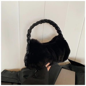 Détail du sac à bandoulière en fausse fourrure noire avec anse en cuir tressé