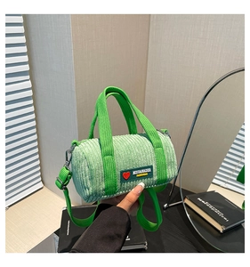 Detail of light green corduroy barrel bag with bright green straps and brand logo