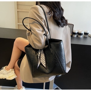 Detail der schwarzen matten Leder-Tote-Bag mit elegantem Karoschal im Café-Stil