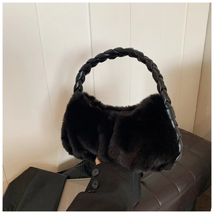 Détail d'un sac à main en peluche noire avec anse en cuir tressé pour l'automne-hiver