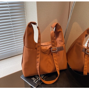 Détail du sac fourre-tout marron avec boucle en métal argenté et poche latérale pratique