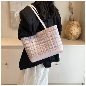 Pink and white checkered tote bag shown on model in a modern minimalist indoor setting