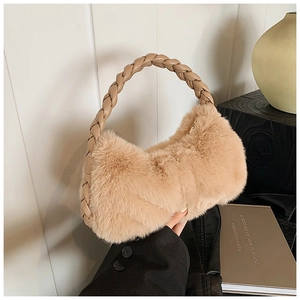 Détail d'un sac à main en peluche camel avec une poignée en cuir tressé en gros plan