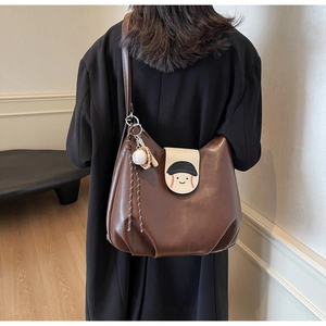 Brown leather crossbody backpack with baseball smiley face pattern on white flap cover