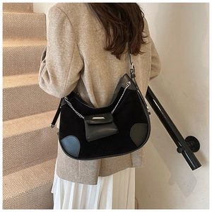 Detailansicht der schwarzen Hobo-Tasche mit Wildleder-Patchwork und Mini-Tasche an Kette