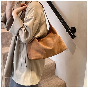Braune Wildleder-Tragetasche kombiniert mit einem beigen Trenchcoat für minimalistischen Look