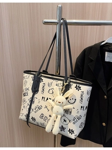 White graffiti tote bag with black handles and bunny pendant for daily commuting