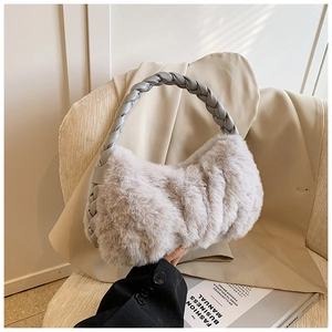Détail d'un sac à main gris en fausse fourrure avec poignée en PU tressé sur veste