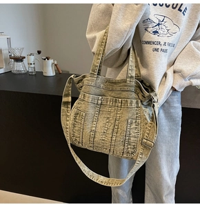 Detail of vintage olive green denim tote bag with triple utility pockets and long strap