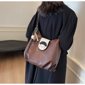 Close-up of brown leather tote bag with baseball embroidery and a ball keychain