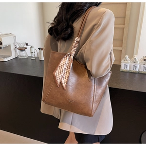 Detail der dunkelbraunen Leder-Shopper mit Vintage-Textur und schickem Karo-Griffschal