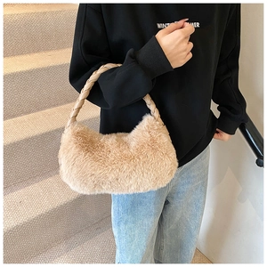 Détail d'un sac à bandoulière en peluche beige avec poignée tressée marron