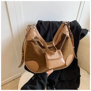 Detail der braunen Vintage-Hobo-Tasche mit Wildlederstruktur und Mini-Anhänger an der Kette
