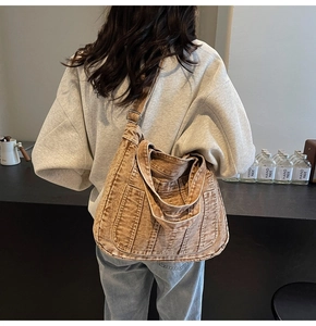 Detail view of washed canvas tote bag featuring vertical stitching and adjustable strap