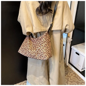 Detailansicht der Leopard-Print-Tragetasche mit schwarzen Lederriemen an einem Model
