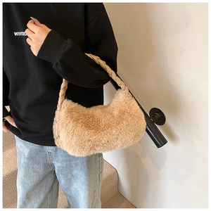 Détail du sac croissant en peluche douce avec poignée en cuir tressé beige en marron clair