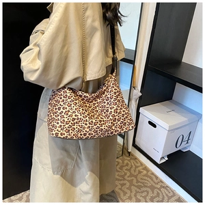 Detailansicht einer Hobo-Tasche mit Leopardenmuster und Lederriemen getragen am Modell