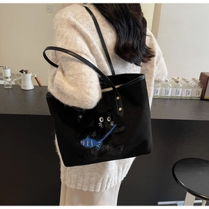 Close-up of black canvas tote bag featuring exquisite cat embroidery and fish detail