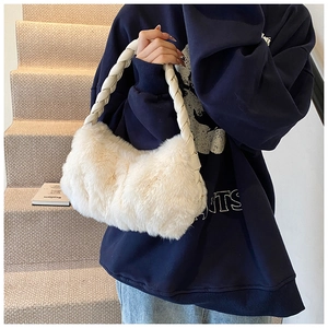 Détail d'un sac à bandoulière en peluche blanc cassé avec une bandoulière en cuir