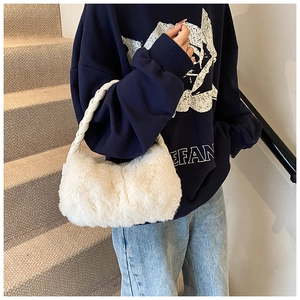 Détail du sac à main en fausse fourrure blanche avec anses tressées en cuir et texture douce