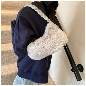 Détail d'un sac à bandoulière en fausse fourrure grise avec bandoulière tressée blanche