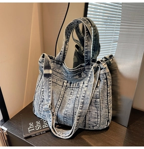 Detailed close-up of retro washed denim tote bag with adjustable strap and multiple pockets
