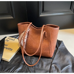 Nahaufnahme der braunen Shopper-Tasche mit Seidenschal und eleganter Logo-Prägung