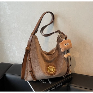 Detail of velvet leopard tote bag with golden M logo and brown leather accents