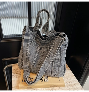 Close-up of vintage washed denim tote bag with multiple pockets and adjustable strap