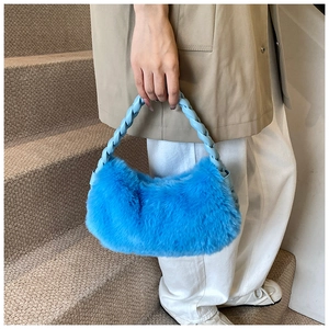 Détail du sac peluche bleu avec poignée tressée bleu clair sur des escaliers