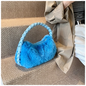Détail d'un sac à main bleu vif en fausse fourrure avec poignée en cuir tissé bleu