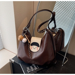 Detail of vintage brown PU leather tote with baseball smile embroidery and sports charms