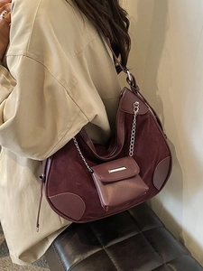 Burgunderfarbene Halbmondtasche mit Wildlederdetails und Mini-Beutel am Modell