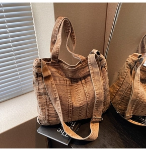 Detailed texture of brown washed denim tote bag with stitching and double pockets