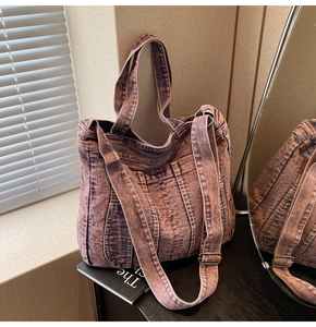 Detail of vintage washed purple denim tote bag with adjustable strap and reinforced stitching