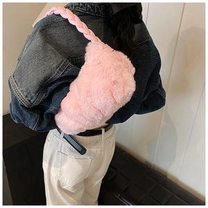 Détail du sac à épaule en peluche rose avec bandoulière tissée épaisse sur un modèle