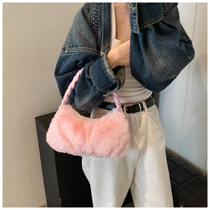 Gros plan d'un sac à main en peluche rose avec poignée tressée et texture en fourrure