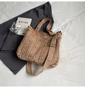 Detail view of brown washed denim tote bag with adjustable strap and stitching