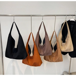 Détail de grands sacs fourre-tout hobo en daim en cinq couleurs Maillard sur cintres