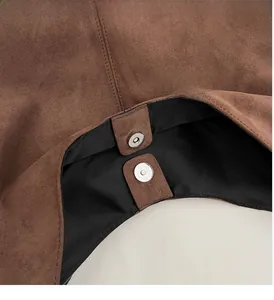Détail du fermoir magnétique sur un sac fourre-tout en daim marron aux coutures fines
