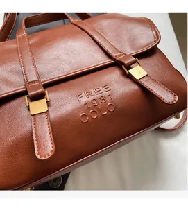 Detail of vintage brown leather texture with gold buckles and embossed logo on tote bag