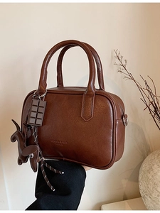 Brown vintage Boston handbag with texture and decorative charms for women
